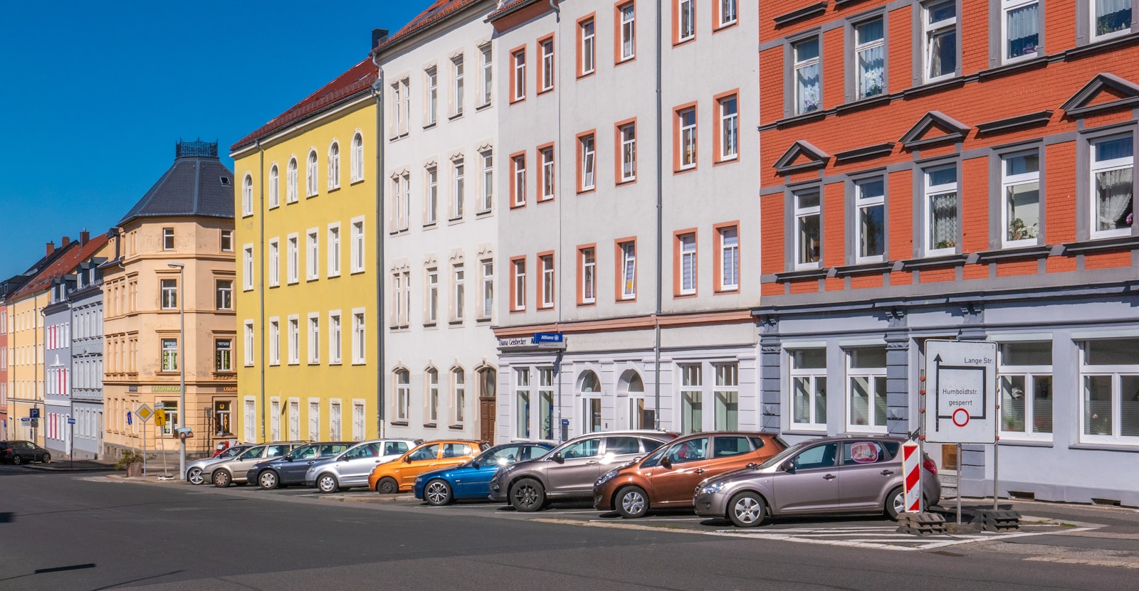 assorted-color cars parked beside apartments filled with tenants who've acquired renters insurance