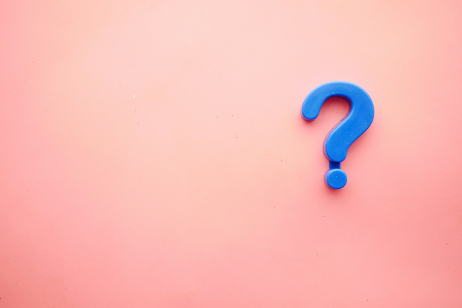 a blue question mark on a pink background symbolizing the question: Why Are My Insurance Rates Increasing?